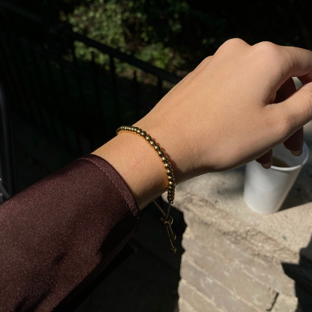 Stylish gold perline bracelet with a distinctive pattern of polished beads, perfect for elevating everyday outfits with a touch of luxury and sophistication.