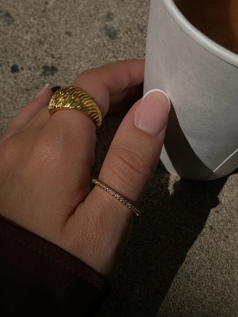 Delicate gold ring featuring a row of shimmering diamonds all around, perfect for a refined and stylish look.