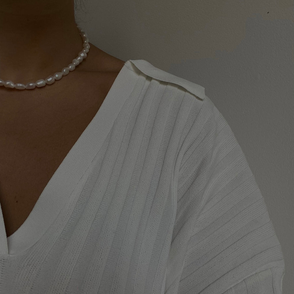 Elegant pearl necklace with perfectly round, shimmering pearls, designed to enhance any ensemble with a touch of timeless beauty and grace.